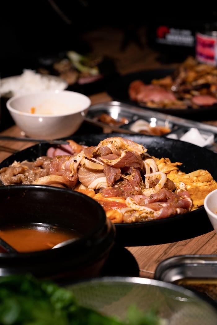 Close-up of a sizzling Korean barbecue platter with sliced meat and vegetables.